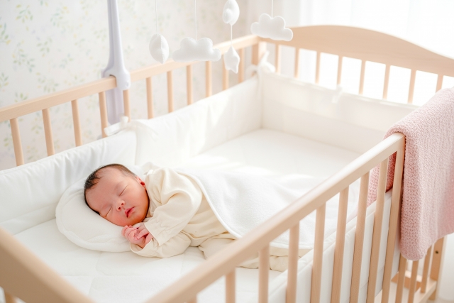 赤ちゃんがベビーベッドで寝ている写真