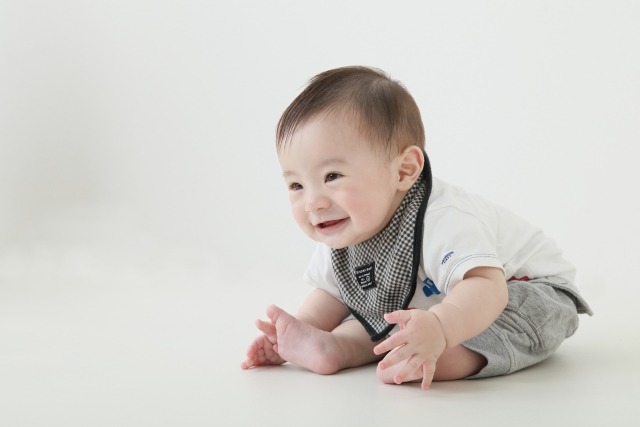 おすわりで微笑む赤ちゃん